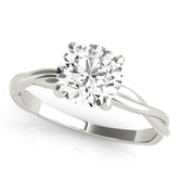 A lab-grown diamond round cut solitaire engagement ring with a twisted band, displayed on a white background.