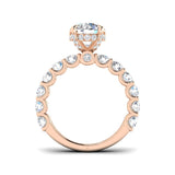 Rose gold ring with a large central gemstone and smaller stones around on a white background