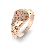 Rose gold ring with star designs and small diamonds on a white background