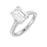Emerald cut diamond engagement ring in white gold with prong set centre and diamond set shoulders