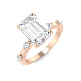 Emerald cut diamond ring featuring round diamond accents on polished band