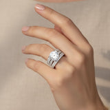 Hand wearing a diamond ring on a neutral background