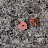 Two small round objects on a textured stone surface