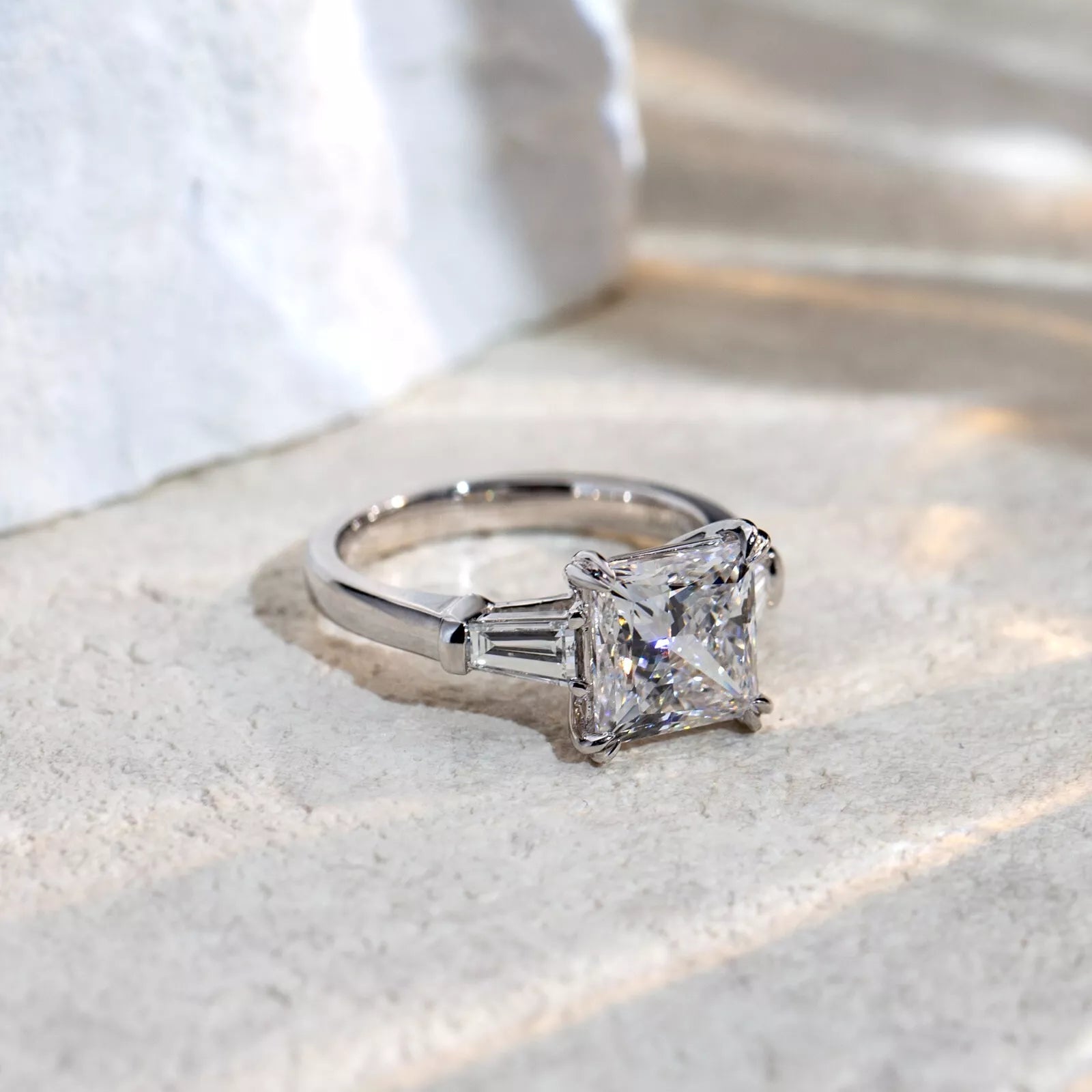 Silver ring with a large diamond on a textured surface