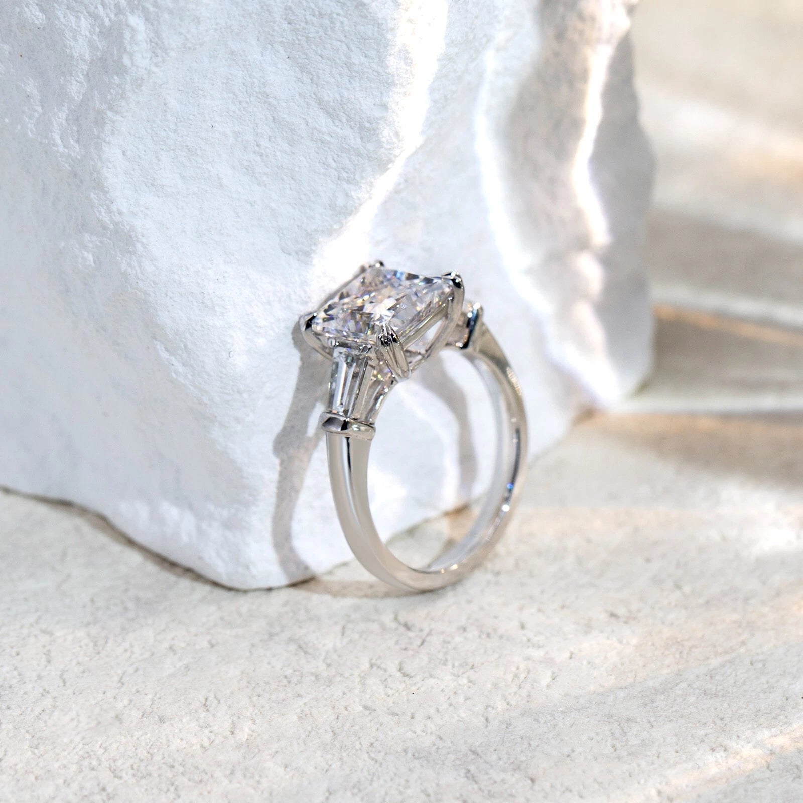 Silver ring with a large diamond on a white fabric background