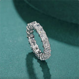 Silver ring with diamonds on a green background