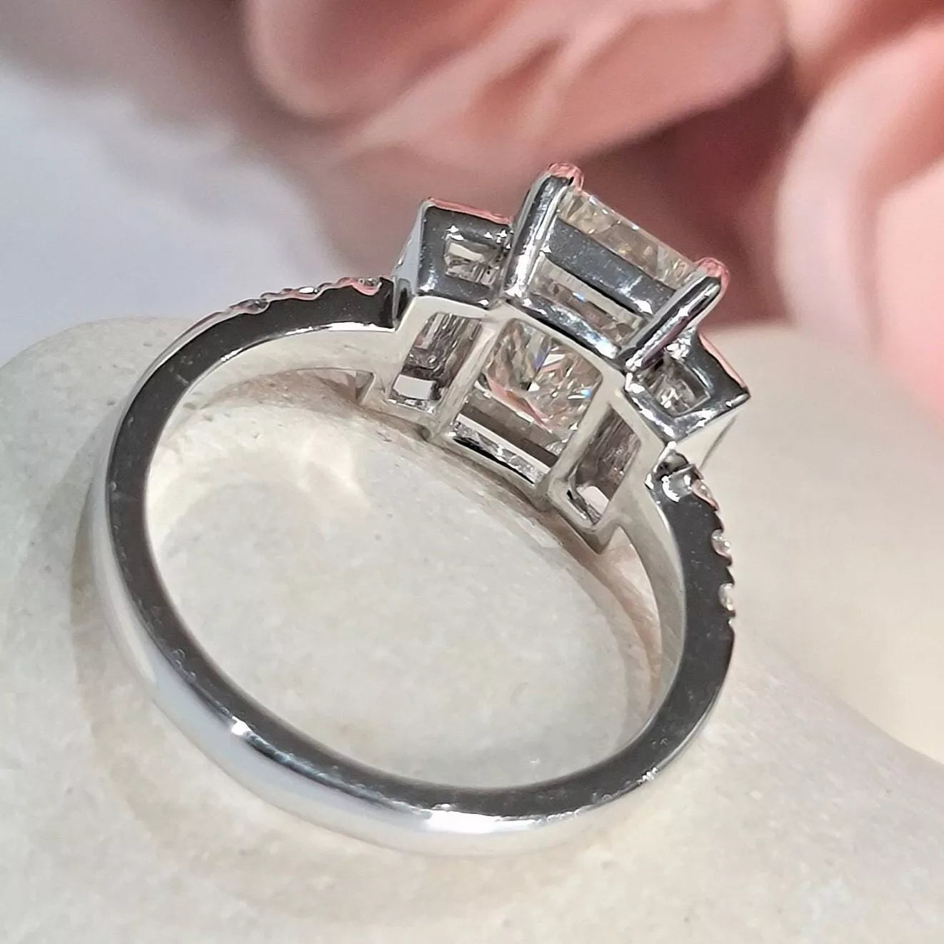 Silver ring with diamond accents on a white surface