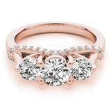 Rose gold ring with three large diamonds and smaller diamonds on a white background