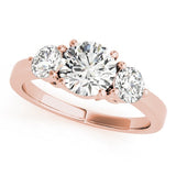 Rose gold ring with three diamonds on a white background