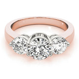 Rose gold ring with three diamond stones on a white background