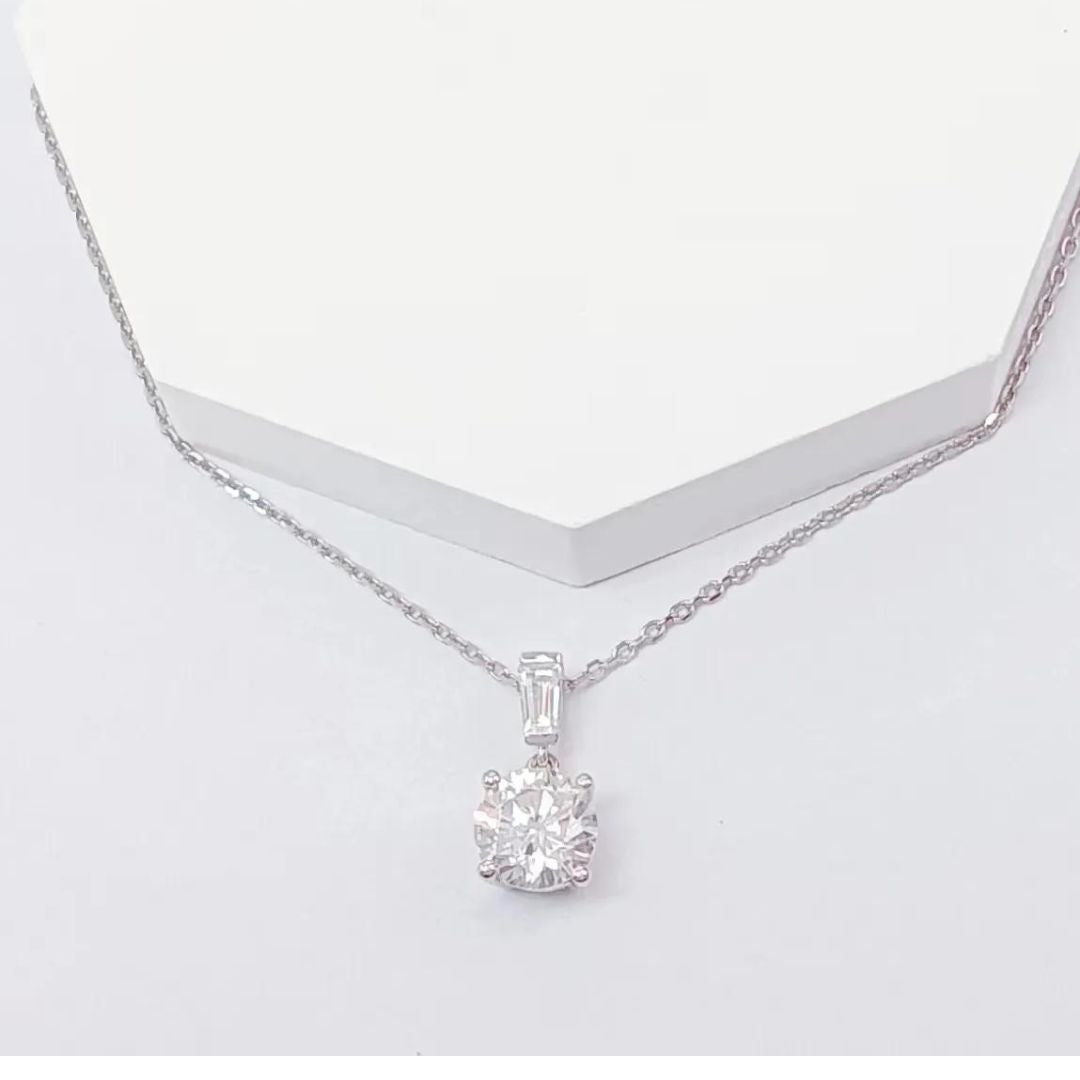 A solitaire round natural diamond pendant necklace in platinum, displayed against a white background.