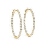 Gold hoop earrings with clear gemstones on a white background