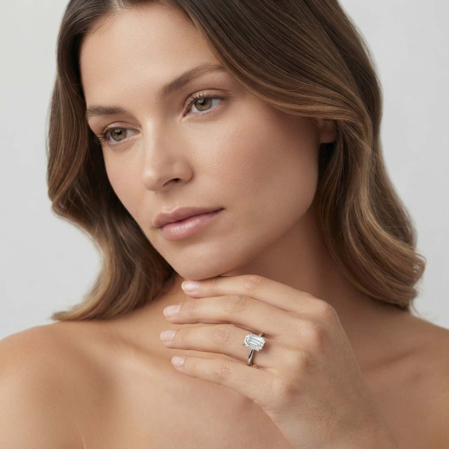 Elegant 18K white gold emerald-cut diamond engagement ring showcasing step-cut facets and a slim band.