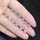 Boucles d'oreilles pendantes Aazuo en or blanc 18 carats, serties de véritables diamants en forme de piriforme et ornées de cinq fleurs féeriques. Idéales pour un mariage, des fiançailles ou une soirée. Au750 