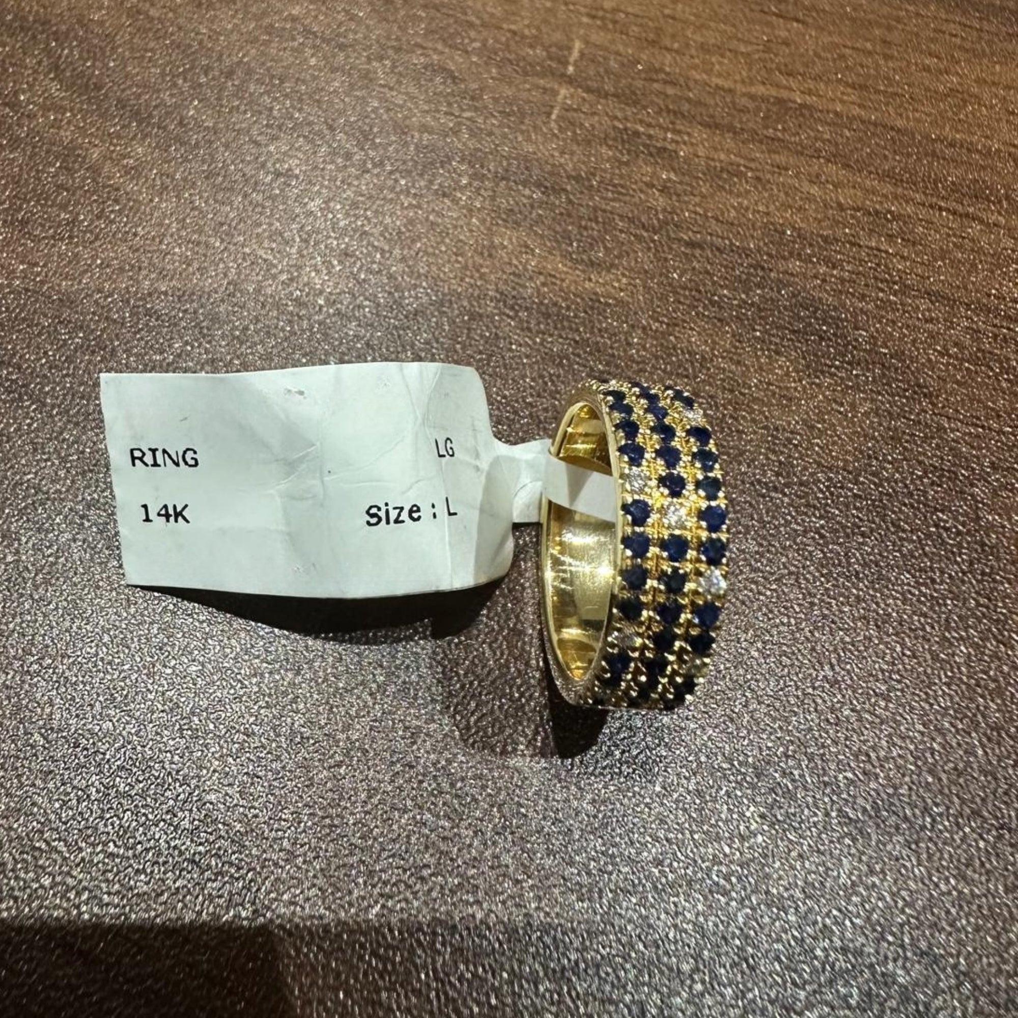 Bague demi-alliance en or jaune 14 carats, sertie d'un saphir bleu taille ronde et de diamants de laboratoire.