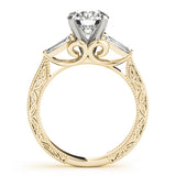 Gold ring with intricate design and diamond on a white background