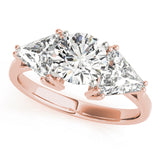 Rose gold ring with a large diamond and two smaller diamonds on a white background