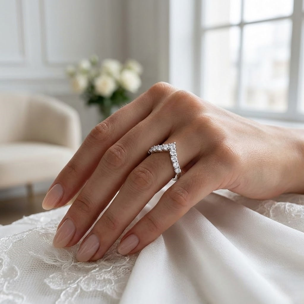Hand wearing a diamond ring with a blurred indoor background