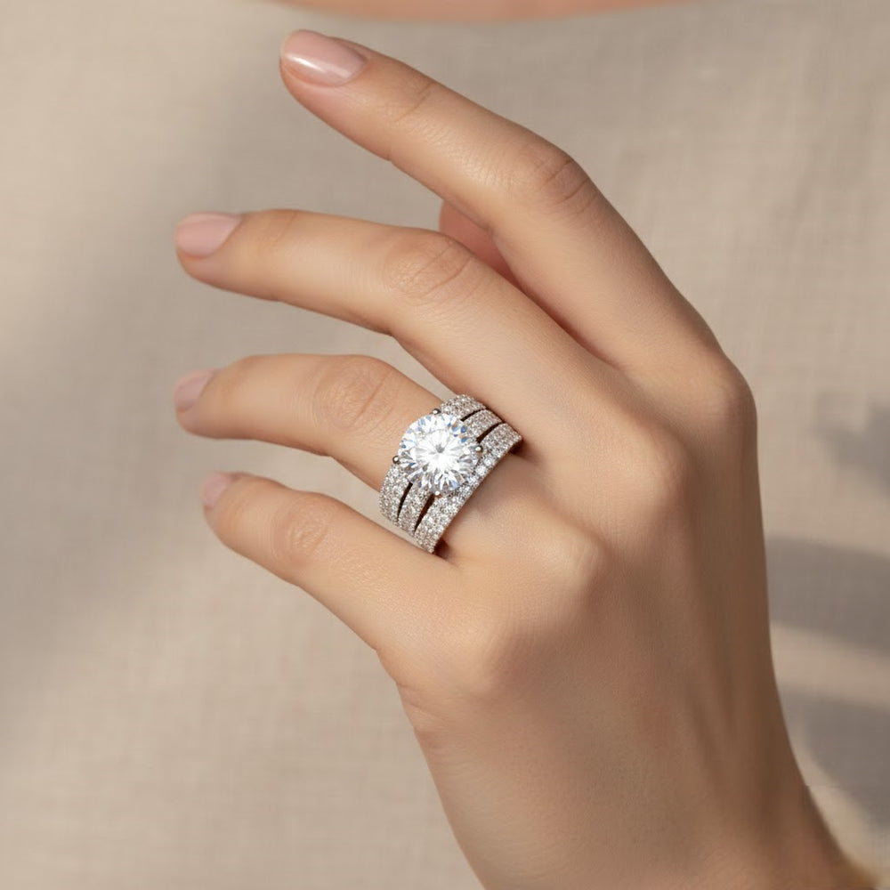 Hand wearing a diamond ring on a neutral background