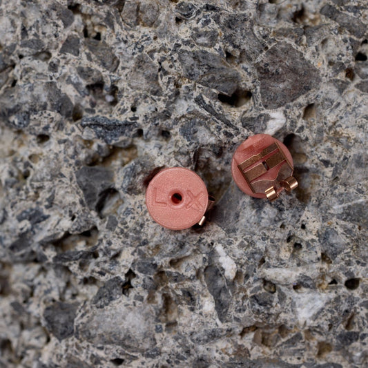 Two small round objects on a textured stone surface