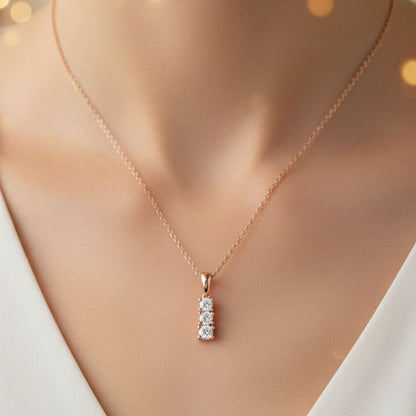 Rose gold necklace with a diamond pendant on a mannequin.
