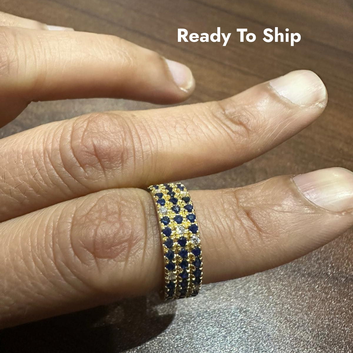 Bague demi-alliance en or jaune 14 carats, sertie d'un saphir bleu taille ronde et de diamants de laboratoire.