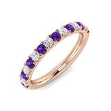 Rose gold ring with purple and clear gemstones on a white background