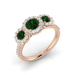 Emerald Three Stone Ring with diamond halo pavé band showcasing vibrant green emeralds in trilogy design.