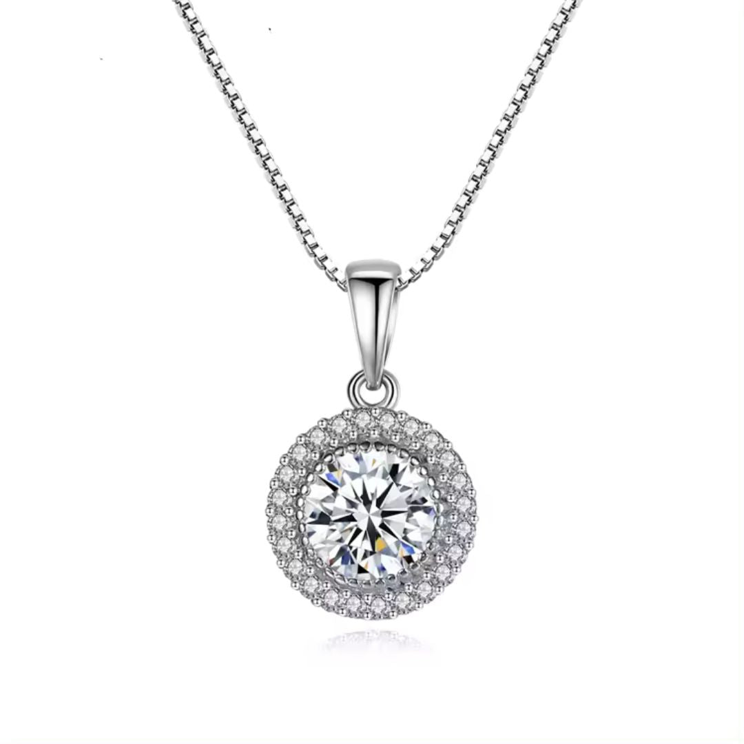 A round solitaire lab grown diamond halo pendant necklace in gold, with a pave setting and a silver chain.