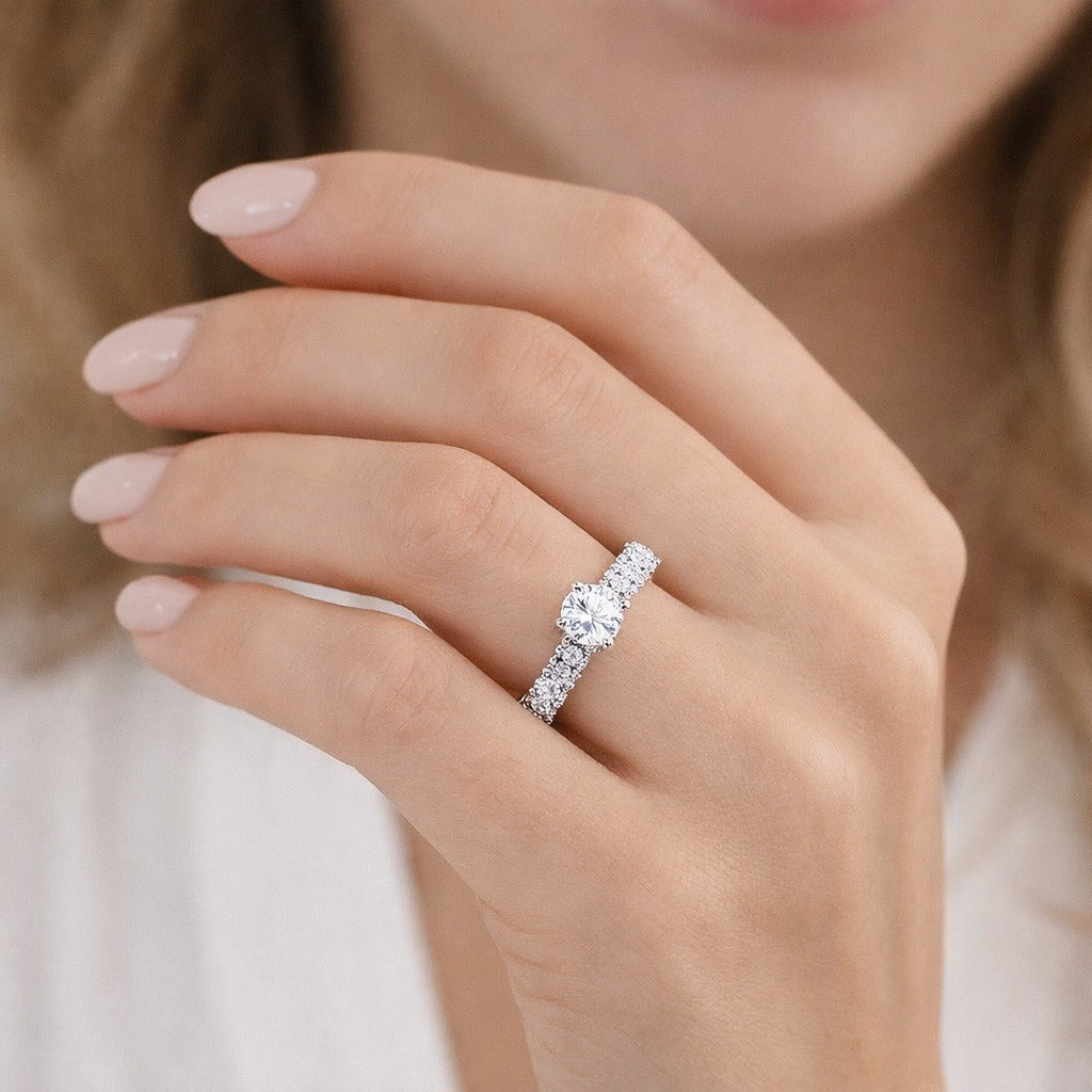 Close-up of a hand wearing a diamond ring with a blurred background