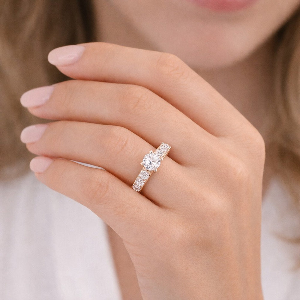 Close-up of a hand wearing a diamond ring with a blurred background