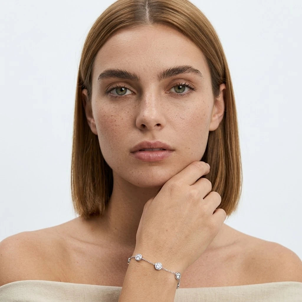 FineDiam delicate white metal chain bracelet featuring round bezel set stones spaced along the chain.