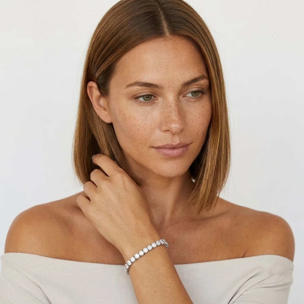 FineDiam diamond tennis bracelet with a continuous row of round stones and visible side settings.