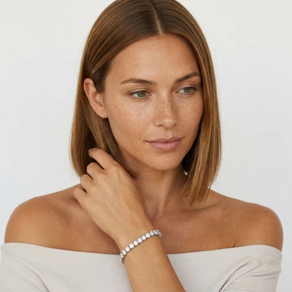 FineDiam diamond tennis bracelet with a continuous row of round stones and visible side settings.