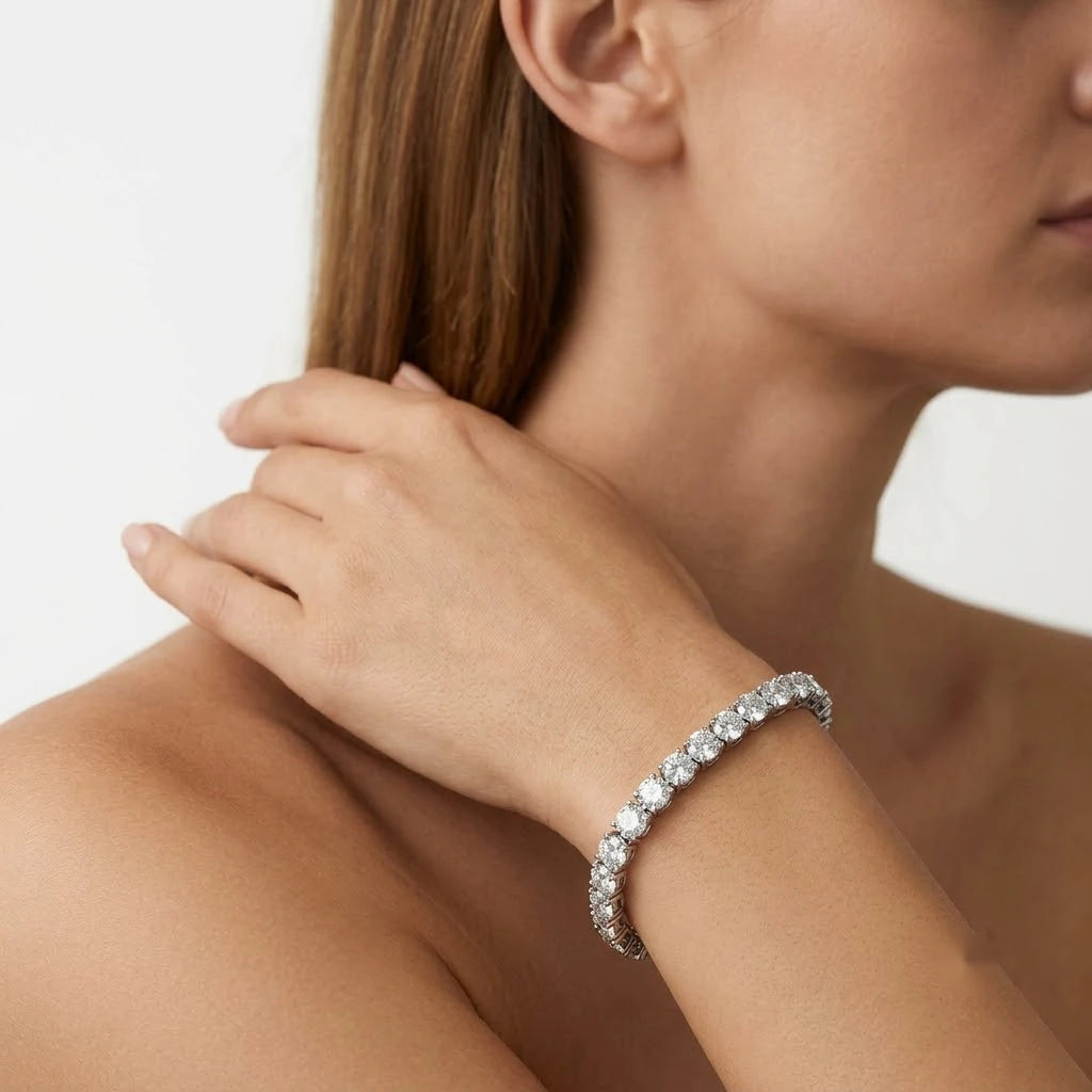 FineDiam diamond tennis bracelet featuring round brilliant stones in a white metal setting.