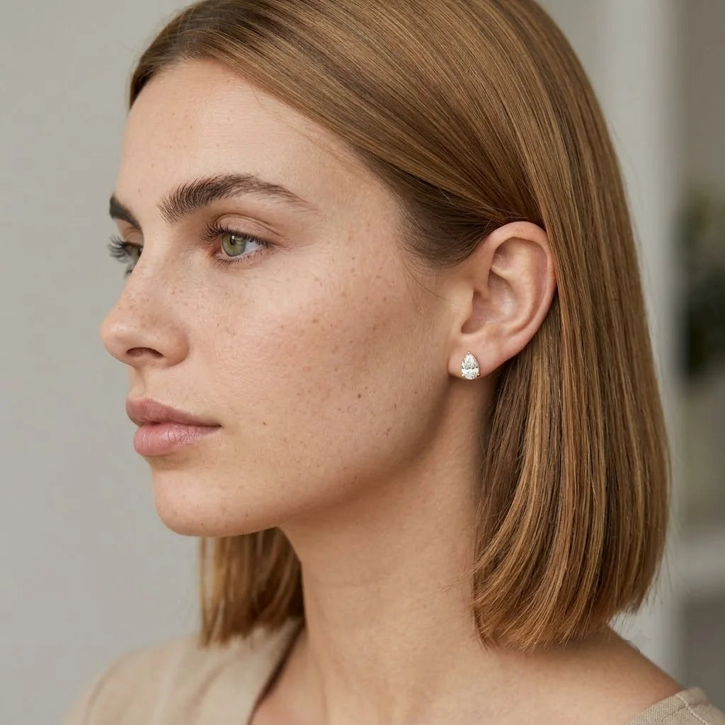 FineDiam pear diamond halo stud earrings featuring a teardrop-shaped setting with sparkling small stones.