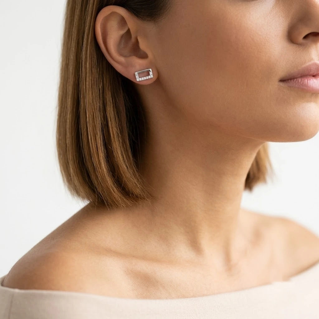 FineDiam rectangular diamond stud earrings with an open centre and small round diamonds set along the white metal frame.