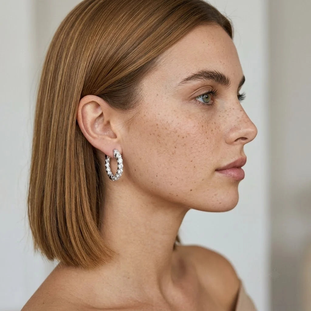 FineDiam white metal diamond hoop earrings featuring a curved row of round stones and an open hoop design.