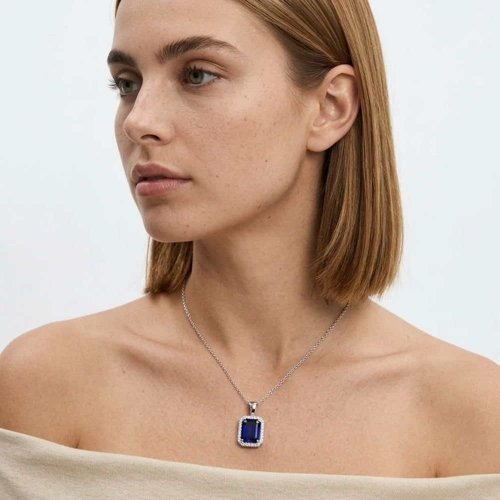 FineDiam rectangular blue gemstone pendant with a sparkling diamond halo and polished white metal chain.