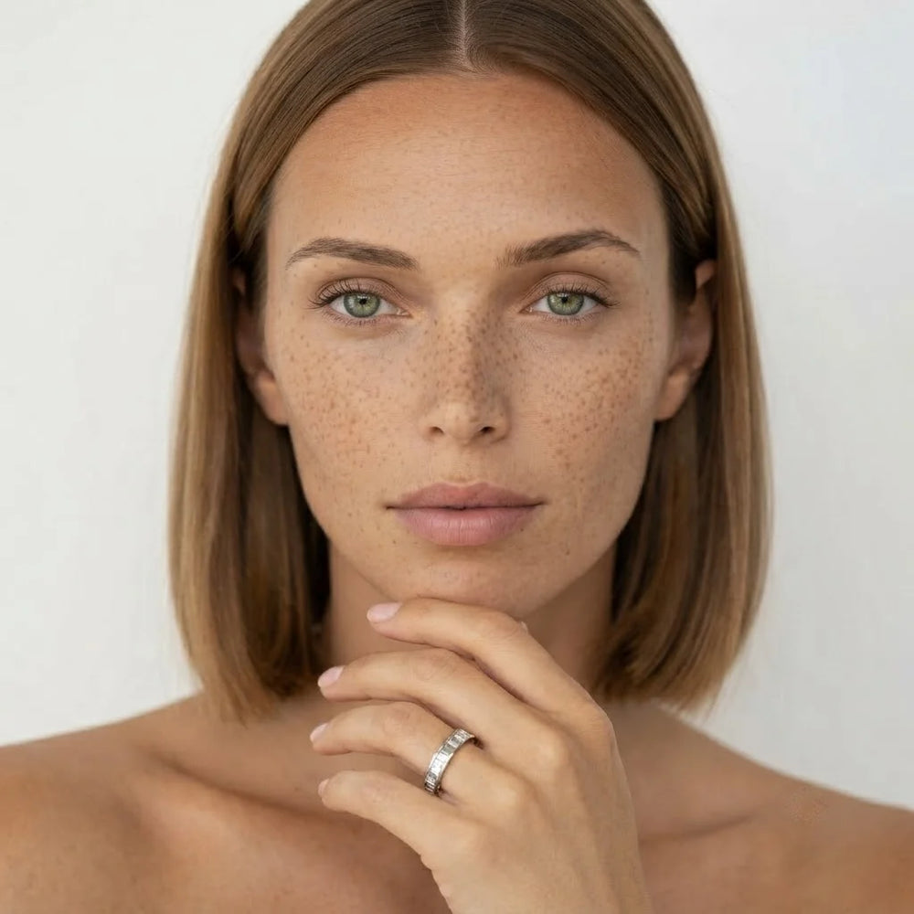 White metal baguette diamond band worn on hand, front-facing model view