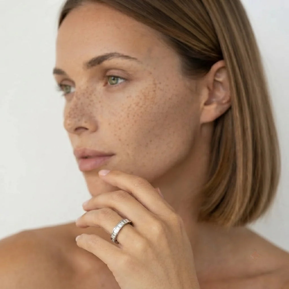 Baguette-cut diamond band in white metal worn on hand, side profile