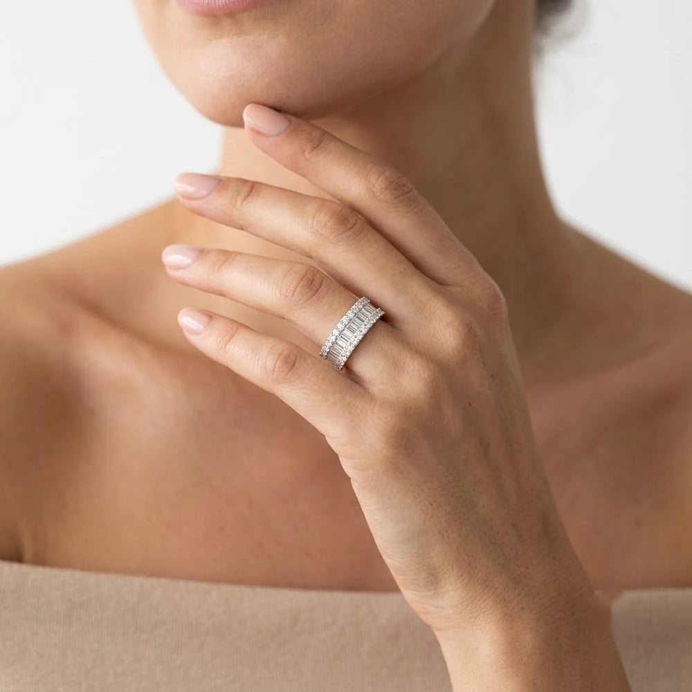 FineDiam white metal diamond band featuring a row of baguette diamonds framed by round pavé set stones.