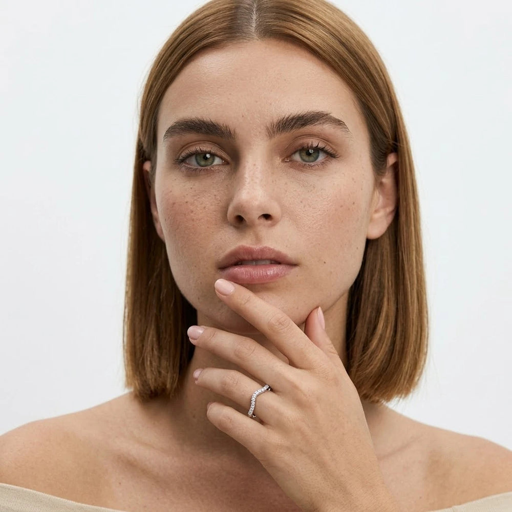 FineDiam curved diamond wedding ring featuring a delicate wave design with small round stones in white metal.