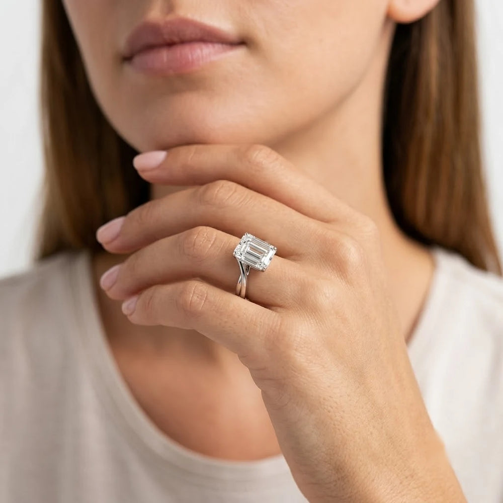 FineDiam emerald cut diamond solitaire ring featuring a rectangular centre stone with a four prong white metal setting.
