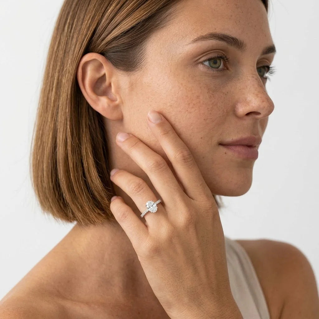 FineDiam oval diamond halo ring featuring a sparkling diamond centre and a slim pave set white metal band.