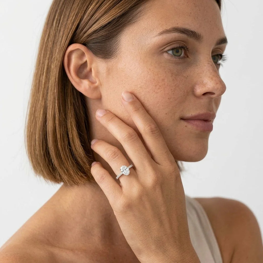 FineDiam oval diamond halo ring featuring a sparkling diamond centre and a slim pave set white metal band.