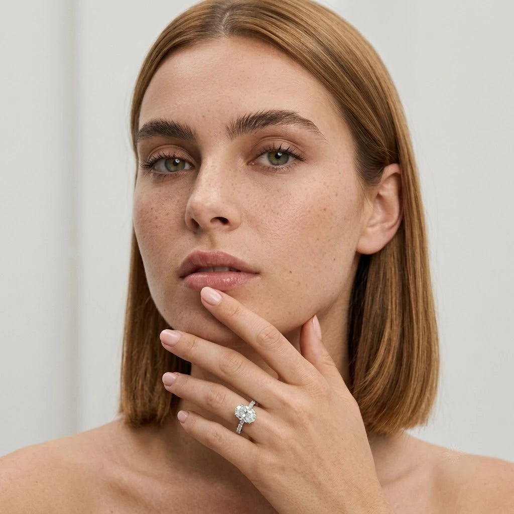 FineDiam oval diamond halo ring featuring a sparkling centre cluster and diamond set shoulders in white metal.