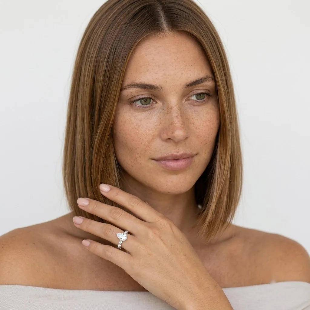  FineDiam pear and round diamond bypass ring featuring sparkling stones in a polished white metal setting.