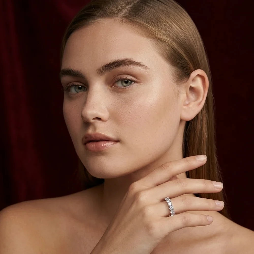 FineDiam white metal round diamond ring worn on a model's hand resting near her chin