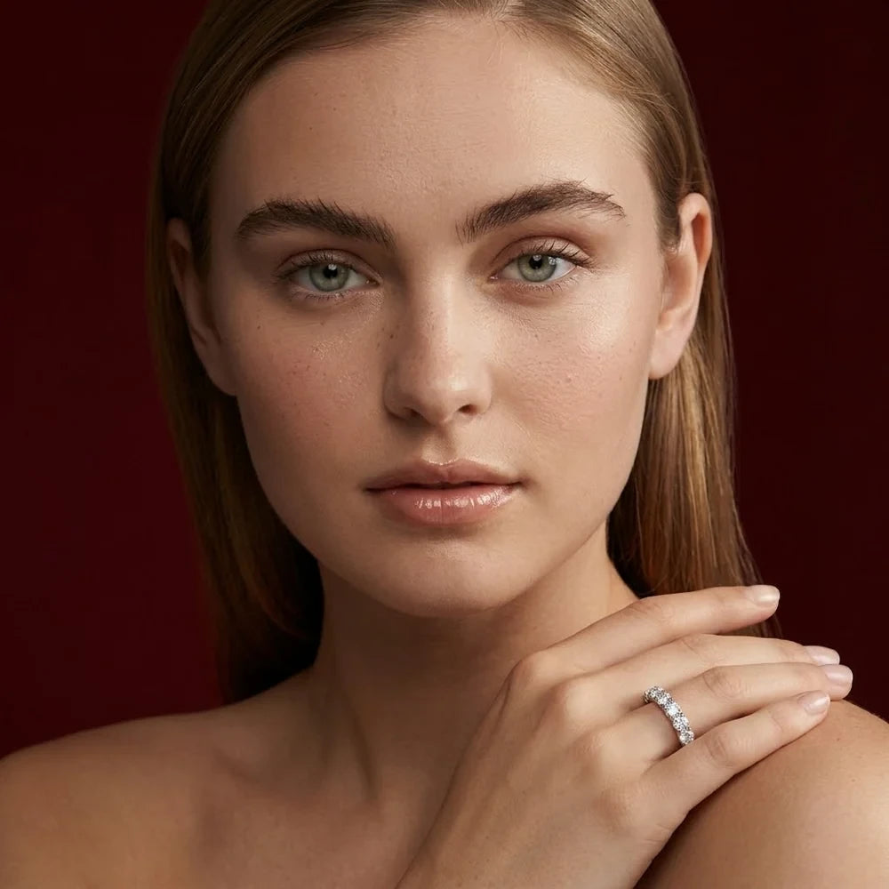 FineDiam white metal diamond ring with round stones displayed on a model's hand resting on her shoulder